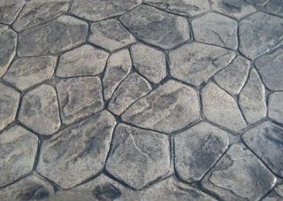 A close up of a concrete floor with a pattern of rocks.