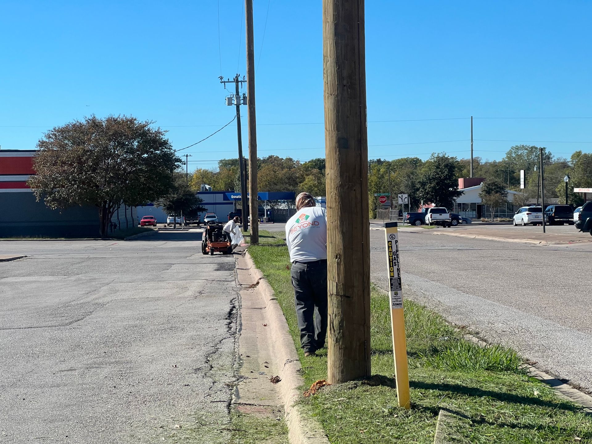 A man standing next to a telephone pole in a parking lot