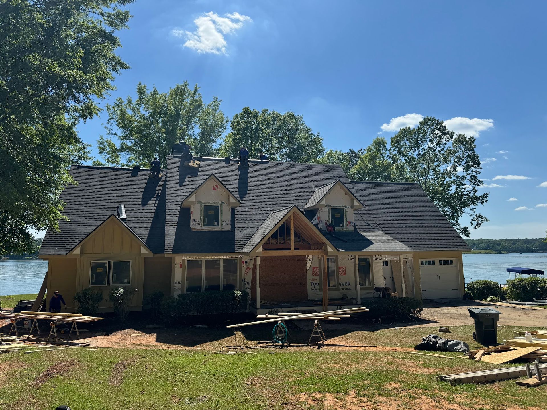 A large house is being built next to a lake.