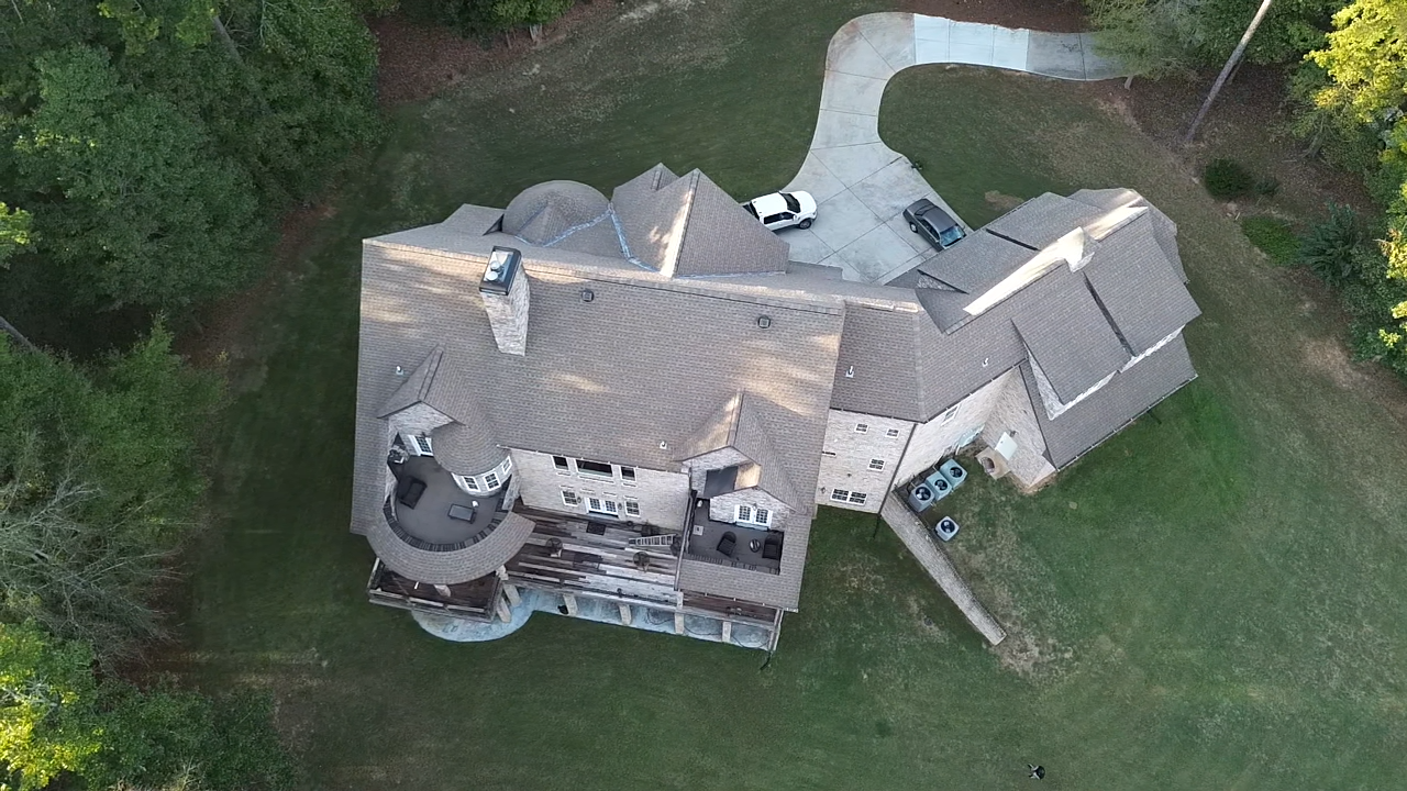 An aerial view of a large house surrounded by trees.