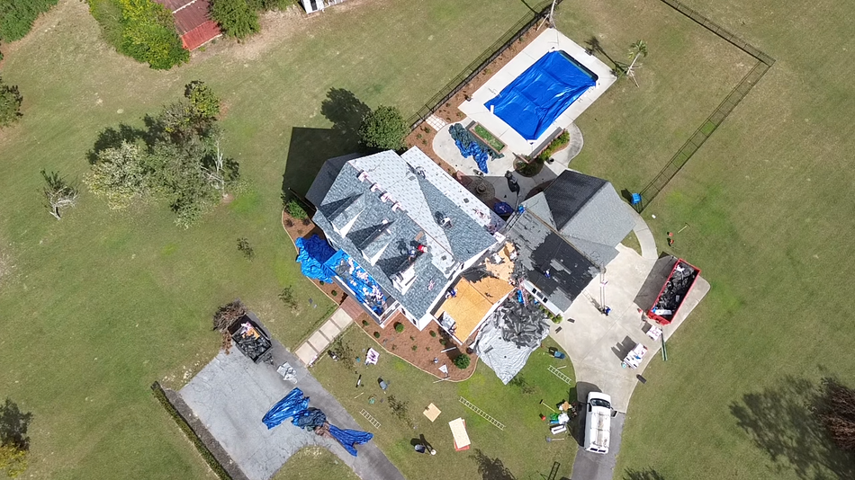 An aerial view of a house with a pool in the backyard.