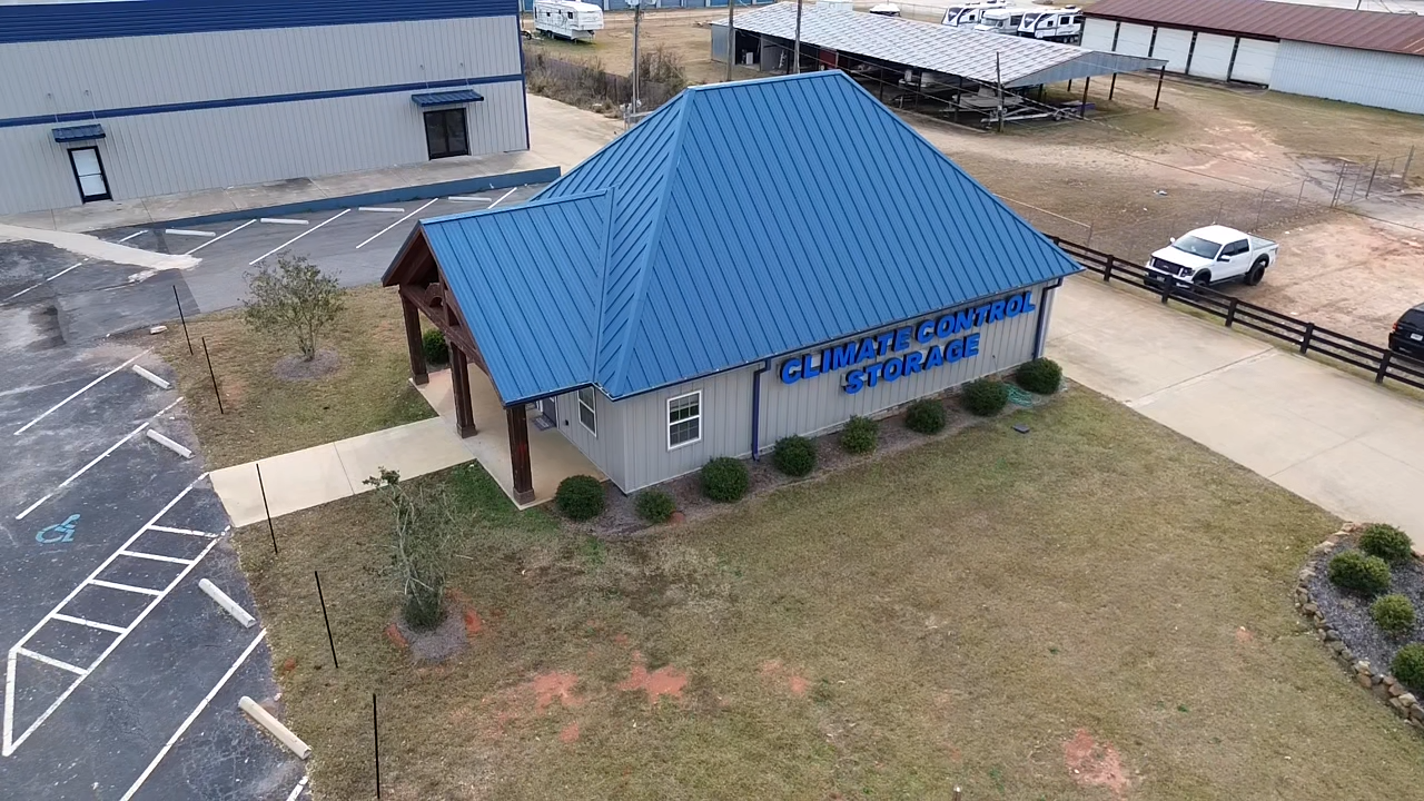 An aerial view of a building with a blue roof in a parking lot.