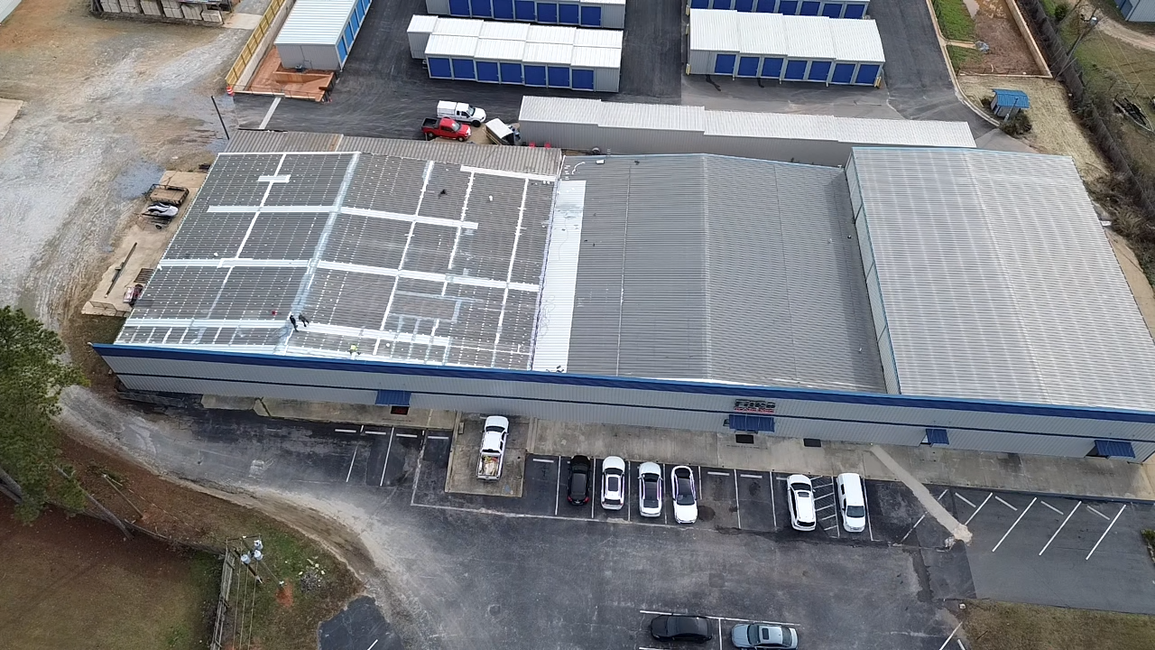 An aerial view of a large building with trucks parked in front of it.