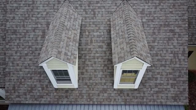 There are two windows on the roof of a house.