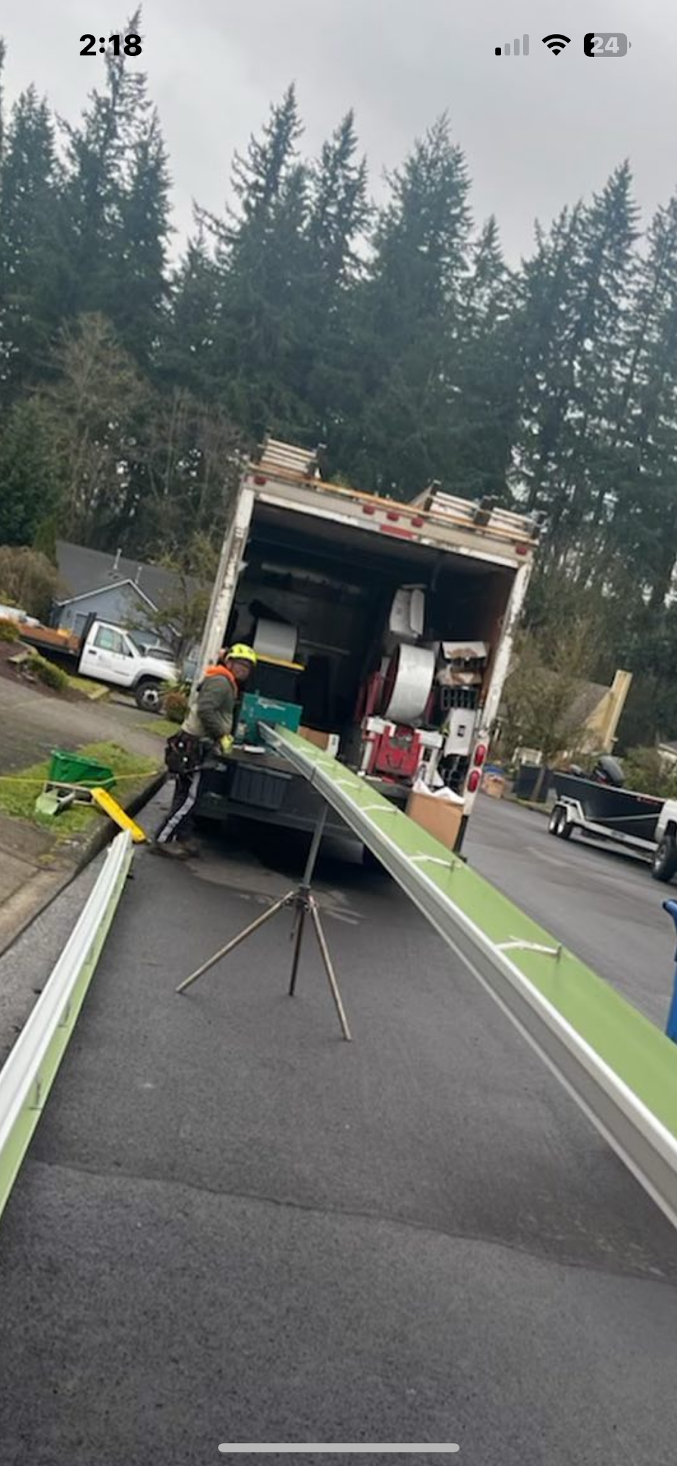 A moving truck is sitting on the side of the road.