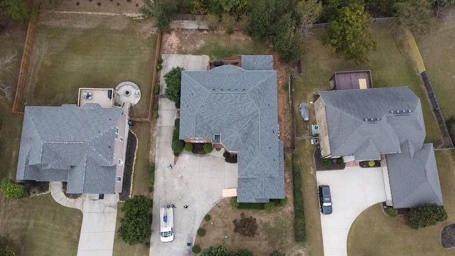 An aerial view of three houses in a residential neighborhood.