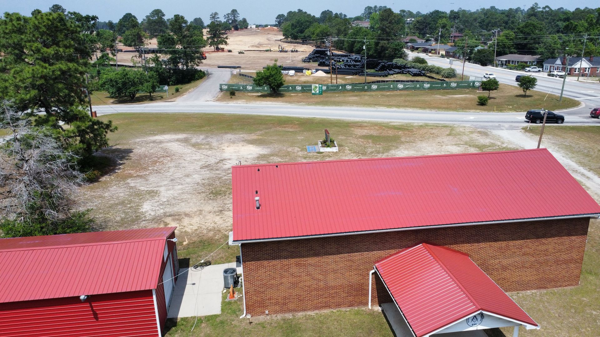 An aerial view of a brick building with a red roof