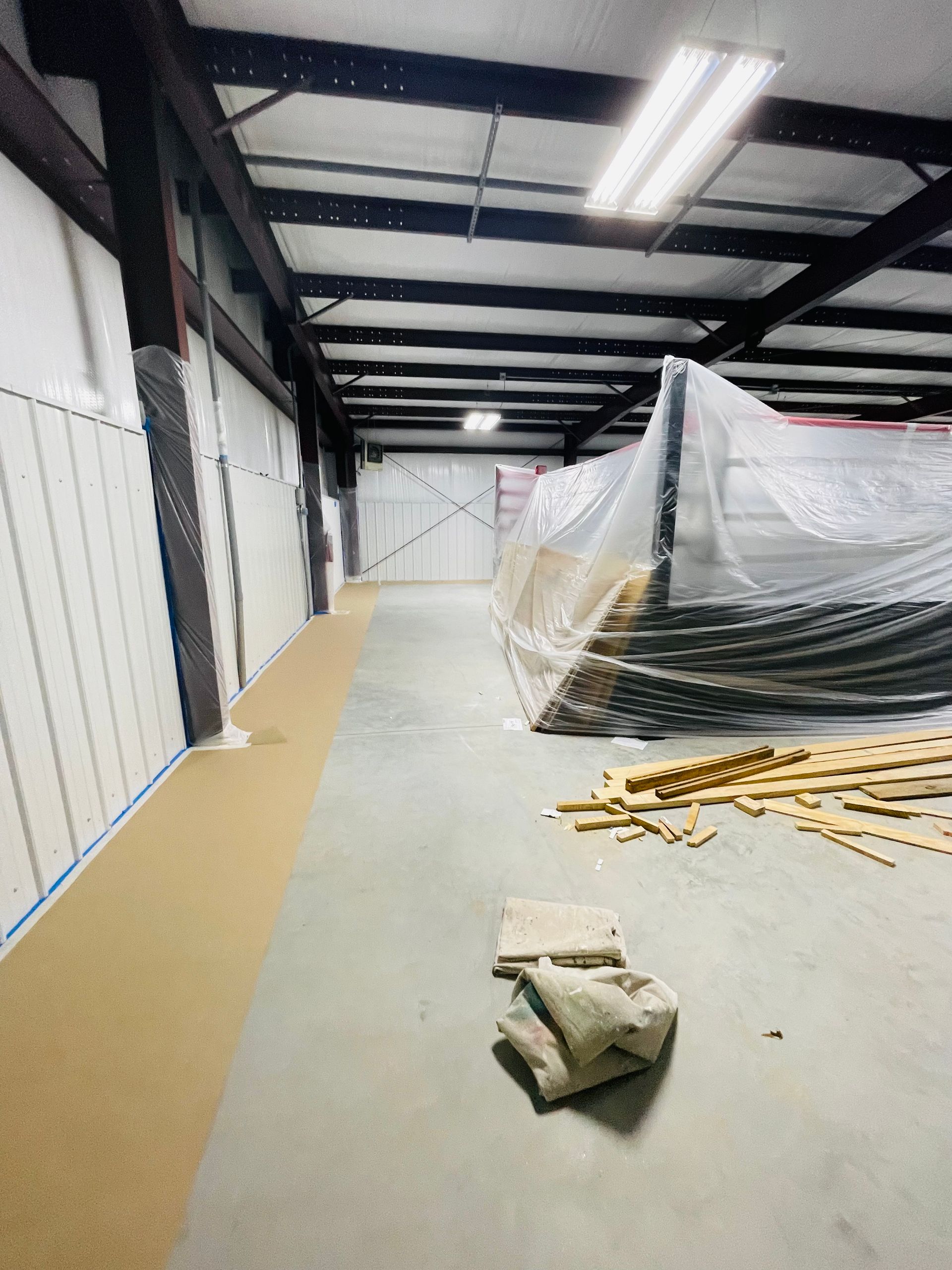 A large empty warehouse with a lot of plastic on the floor.