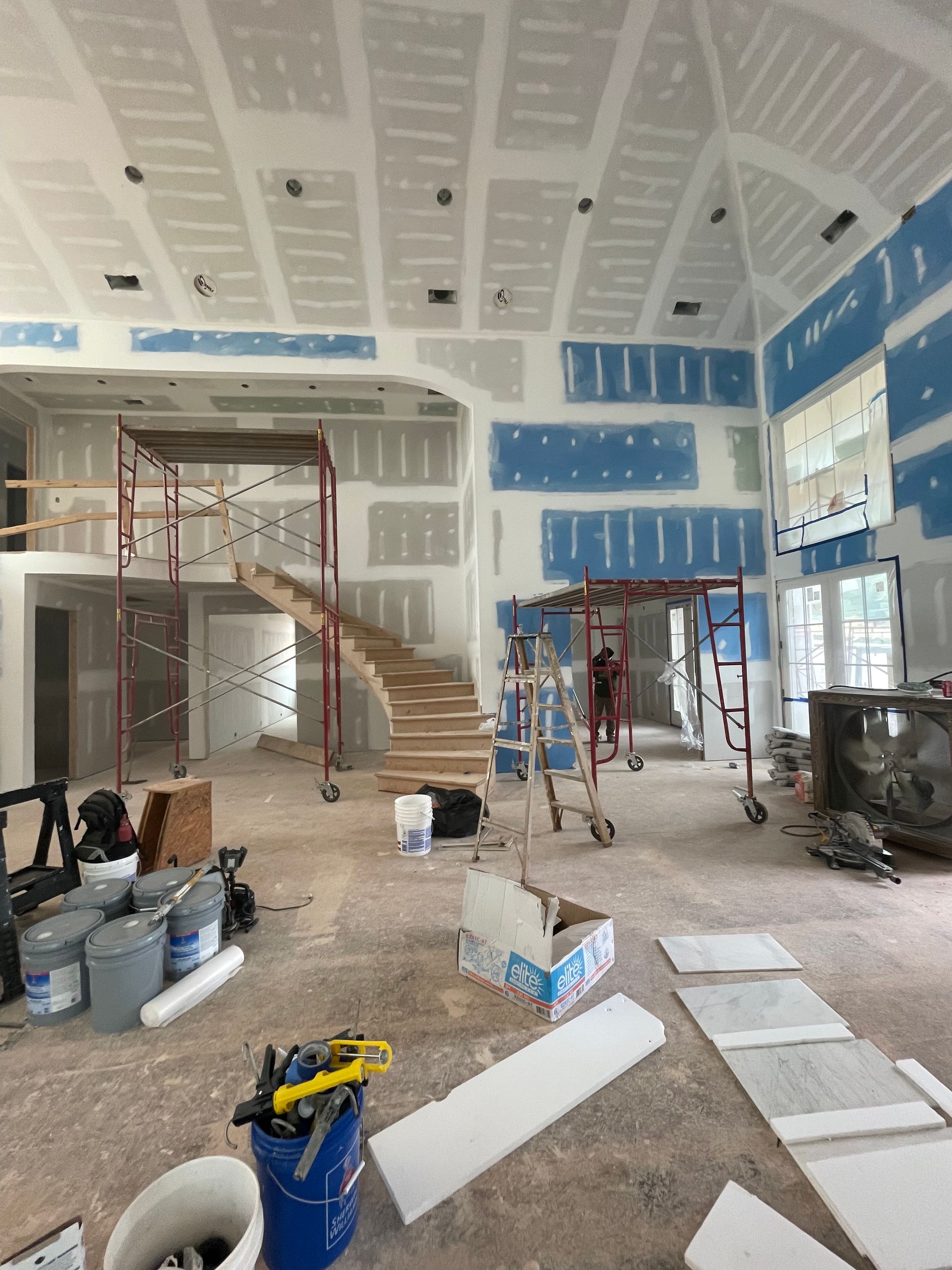 A large room under construction with a staircase in the middle