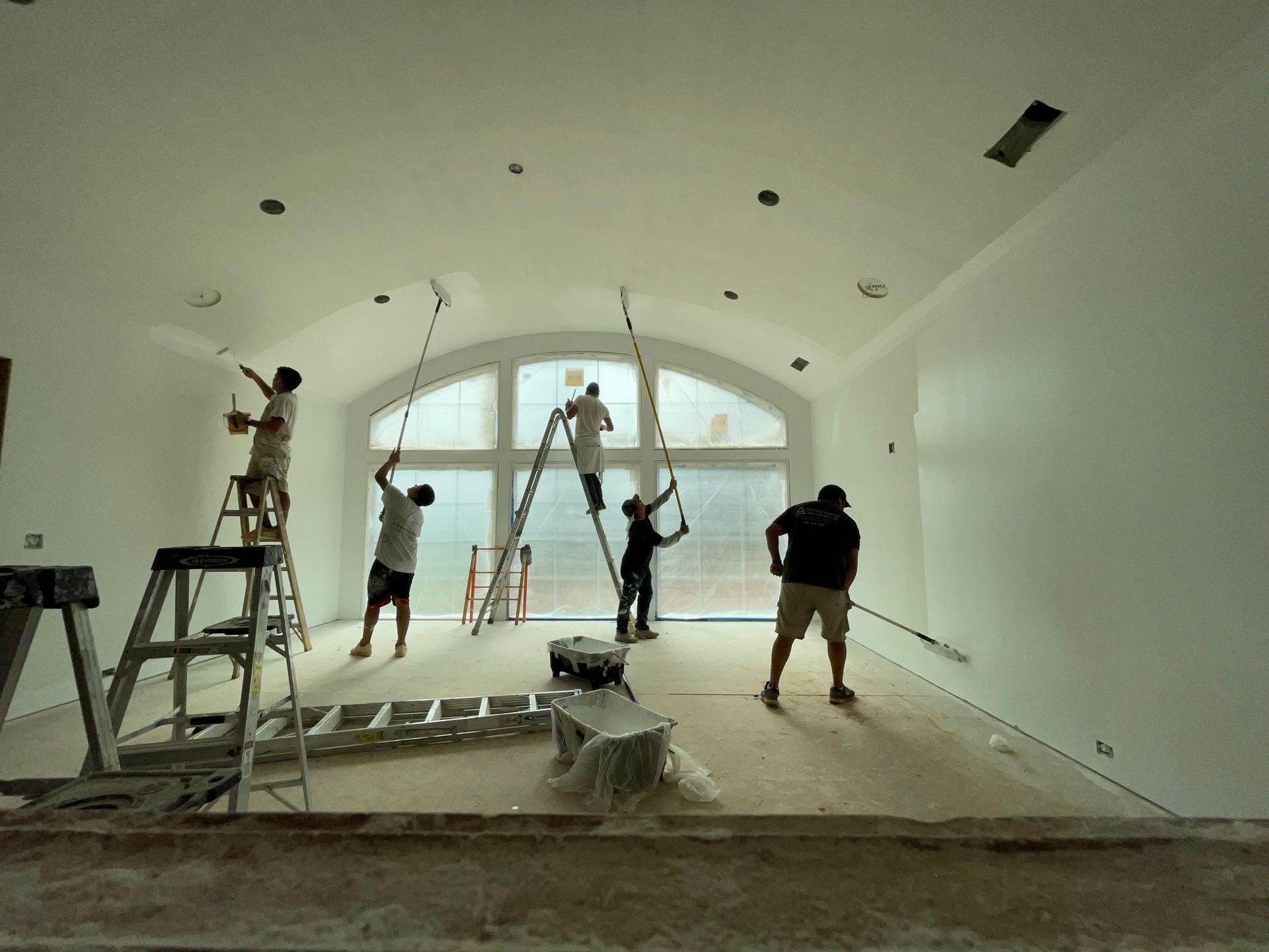 A group of people are painting a large room