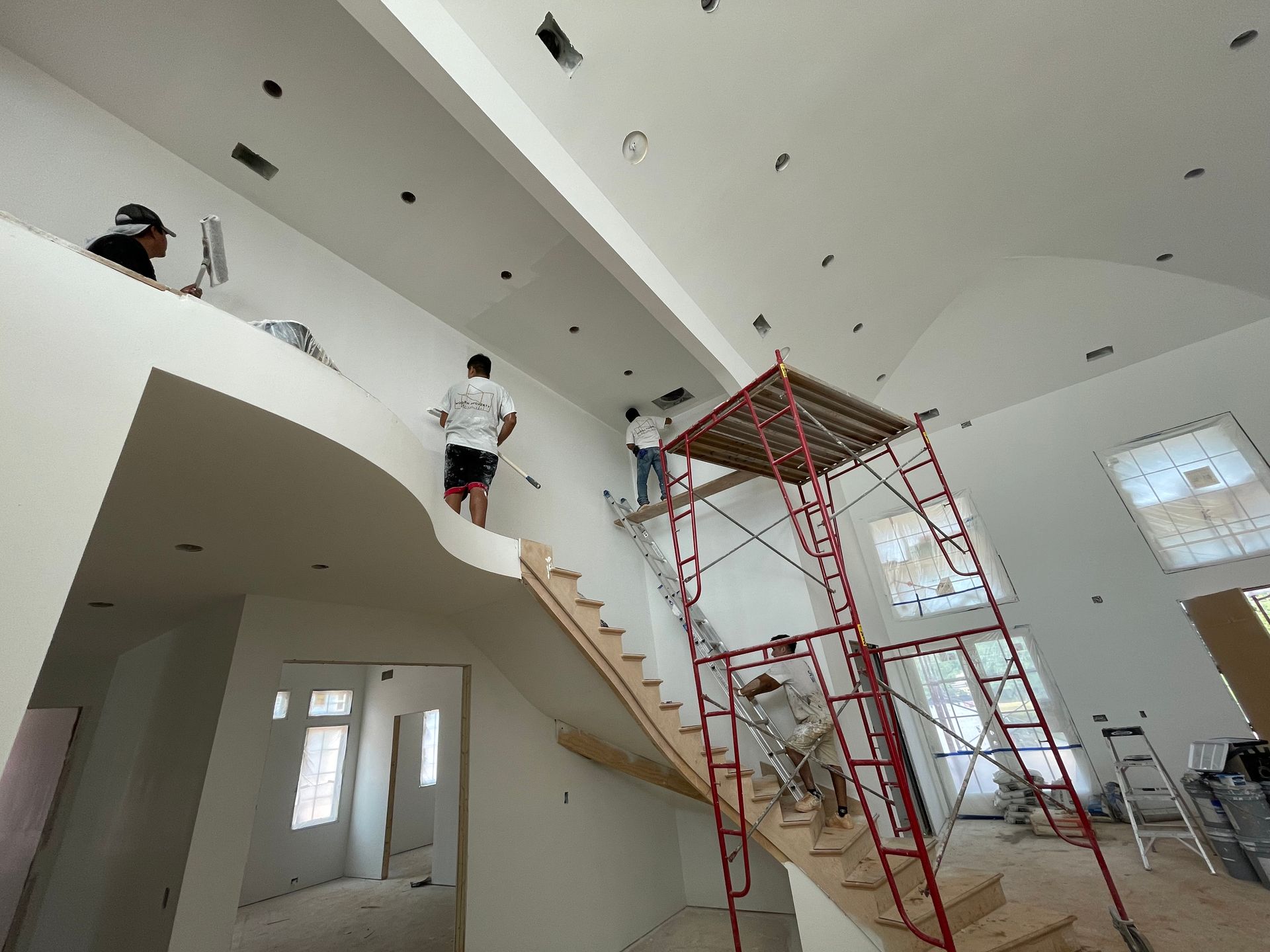 A group of people are painting the walls of a house