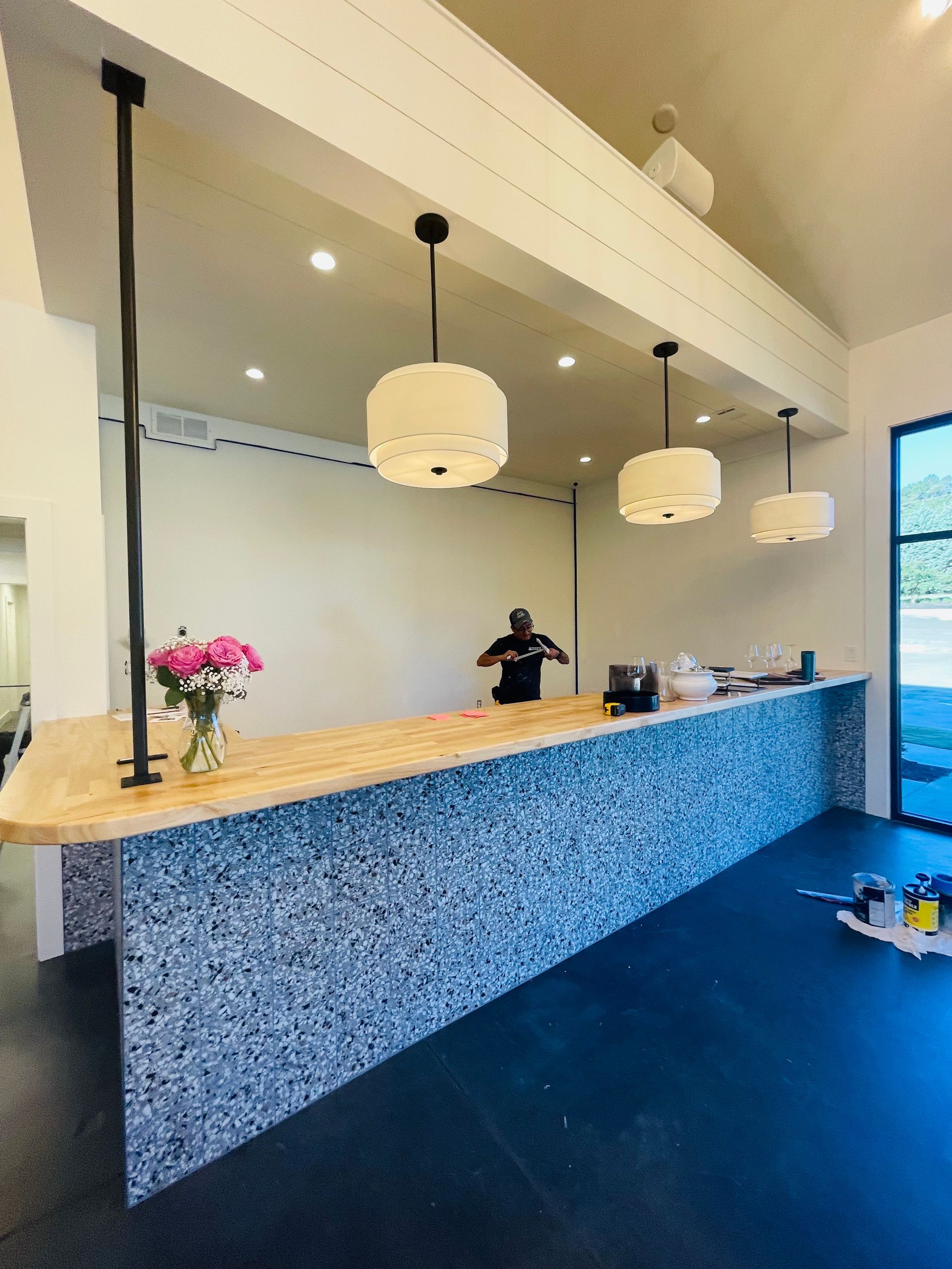 A man is standing behind a long counter in a room.