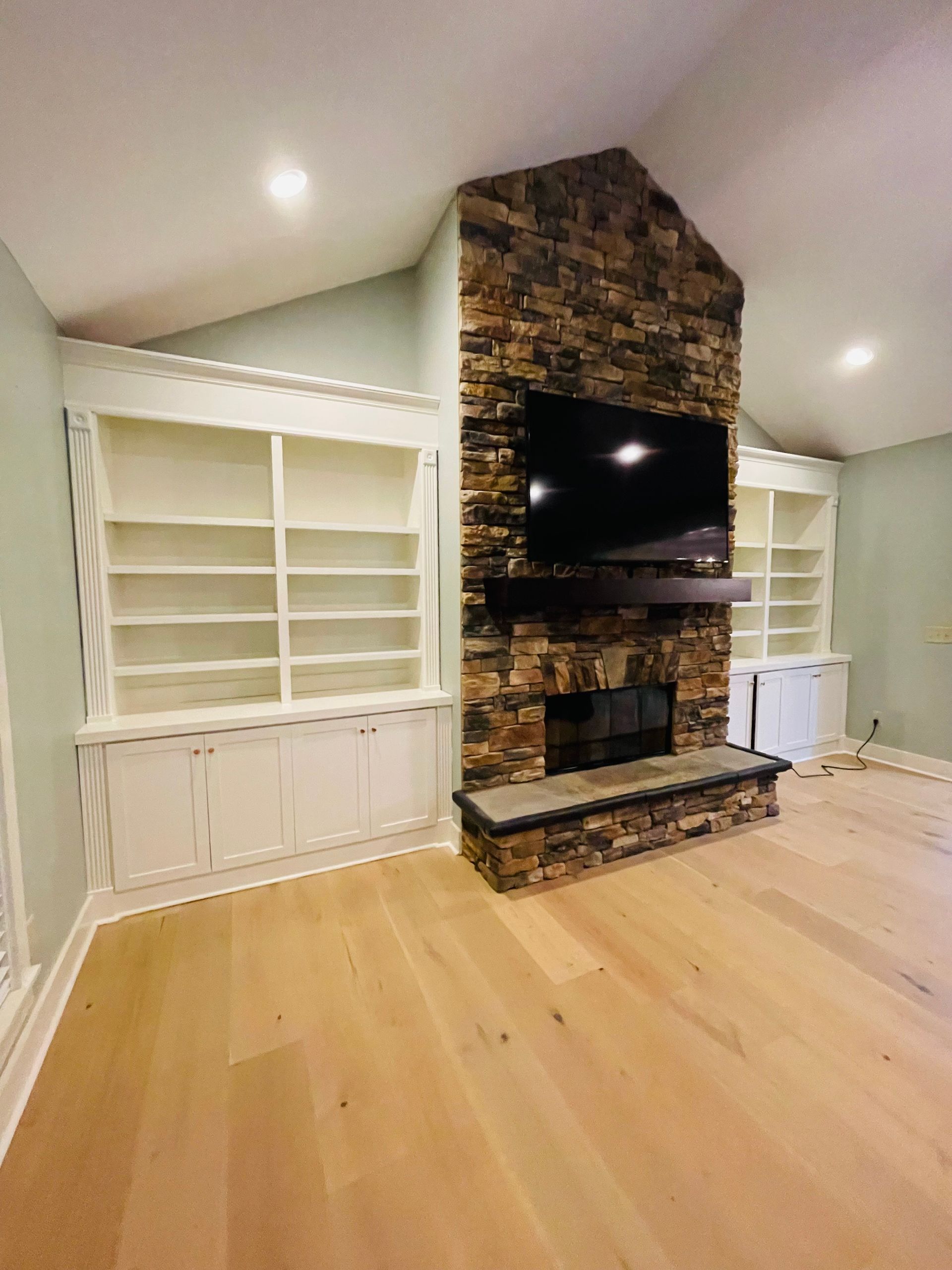 A living room with a fireplace and a flat screen tv.