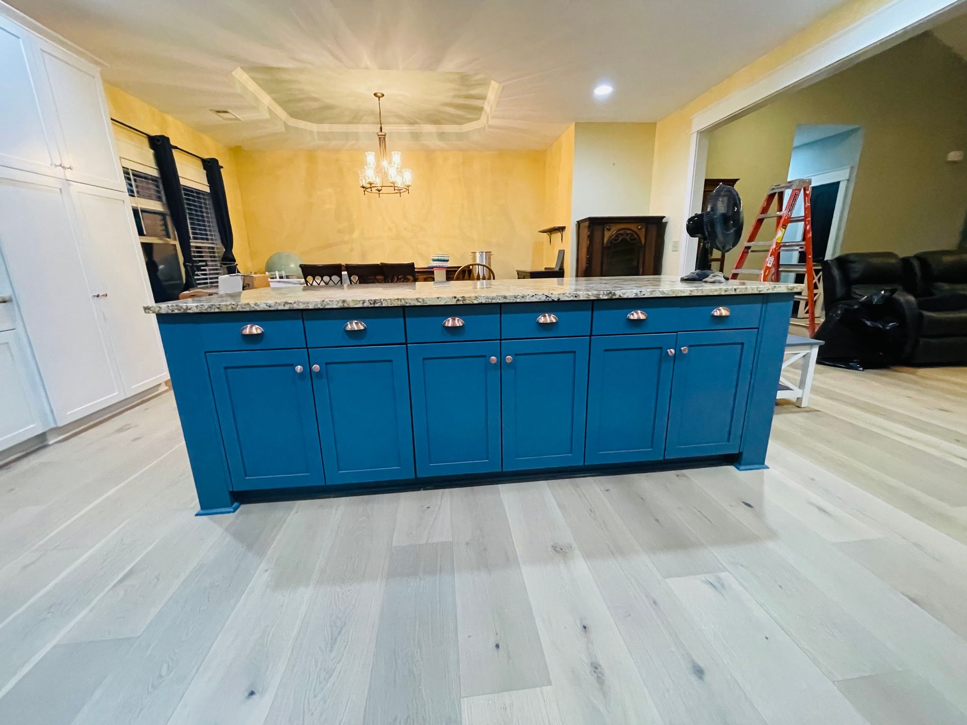 A kitchen with blue cabinets and a large island in the middle of the room.