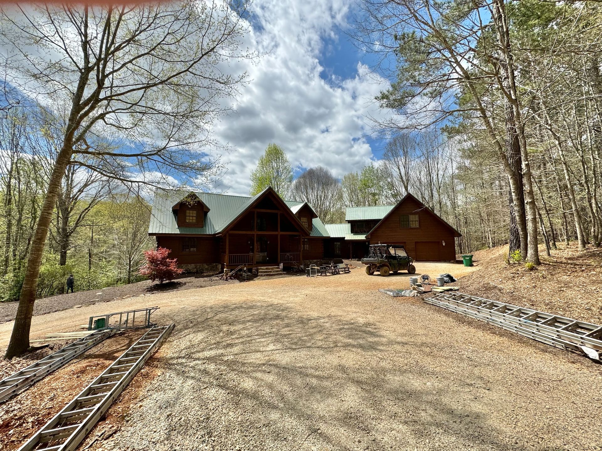 A large log cabin is sitting in the middle of a forest.
