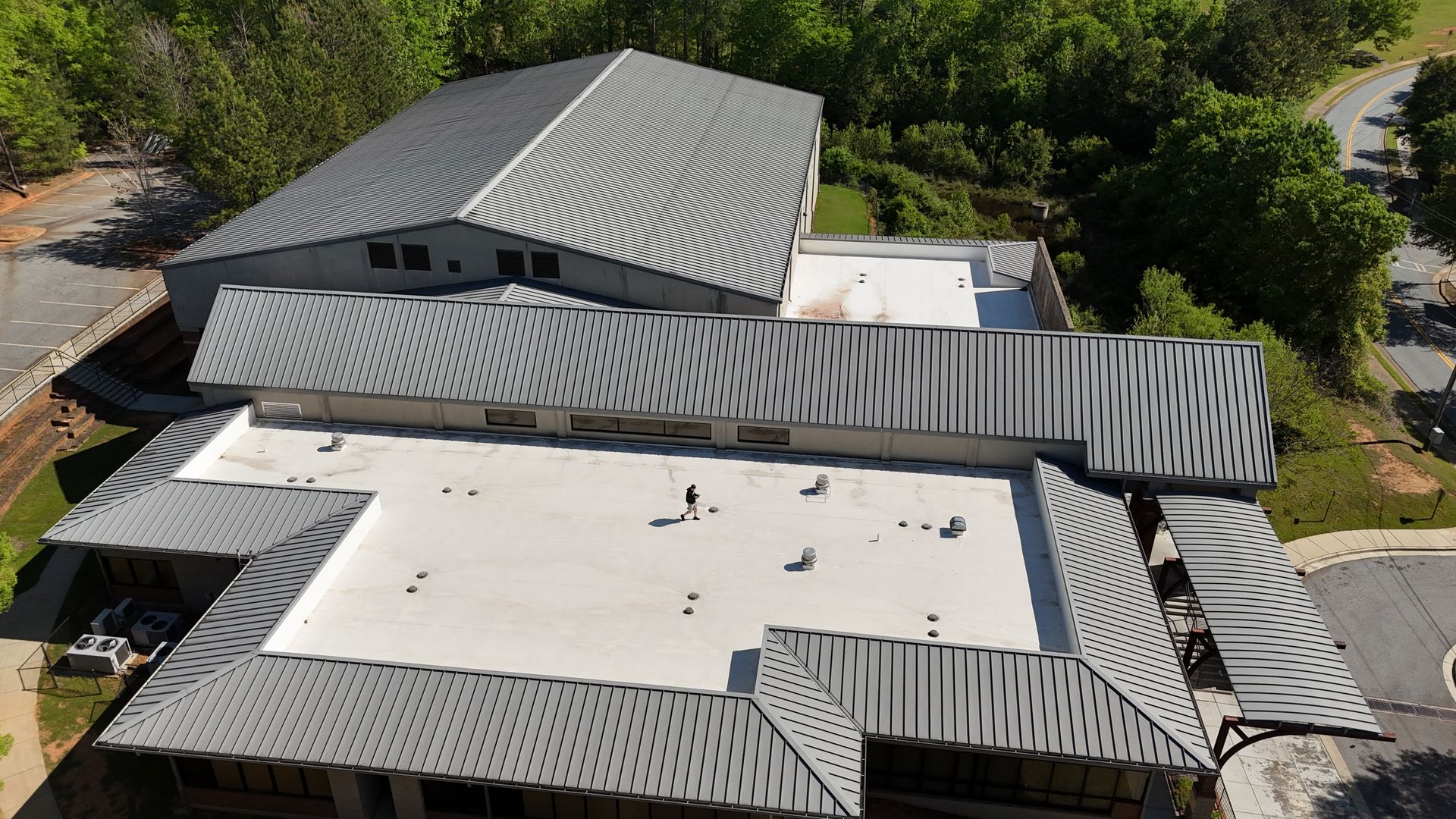 An aerial view of a large building with a white roof
