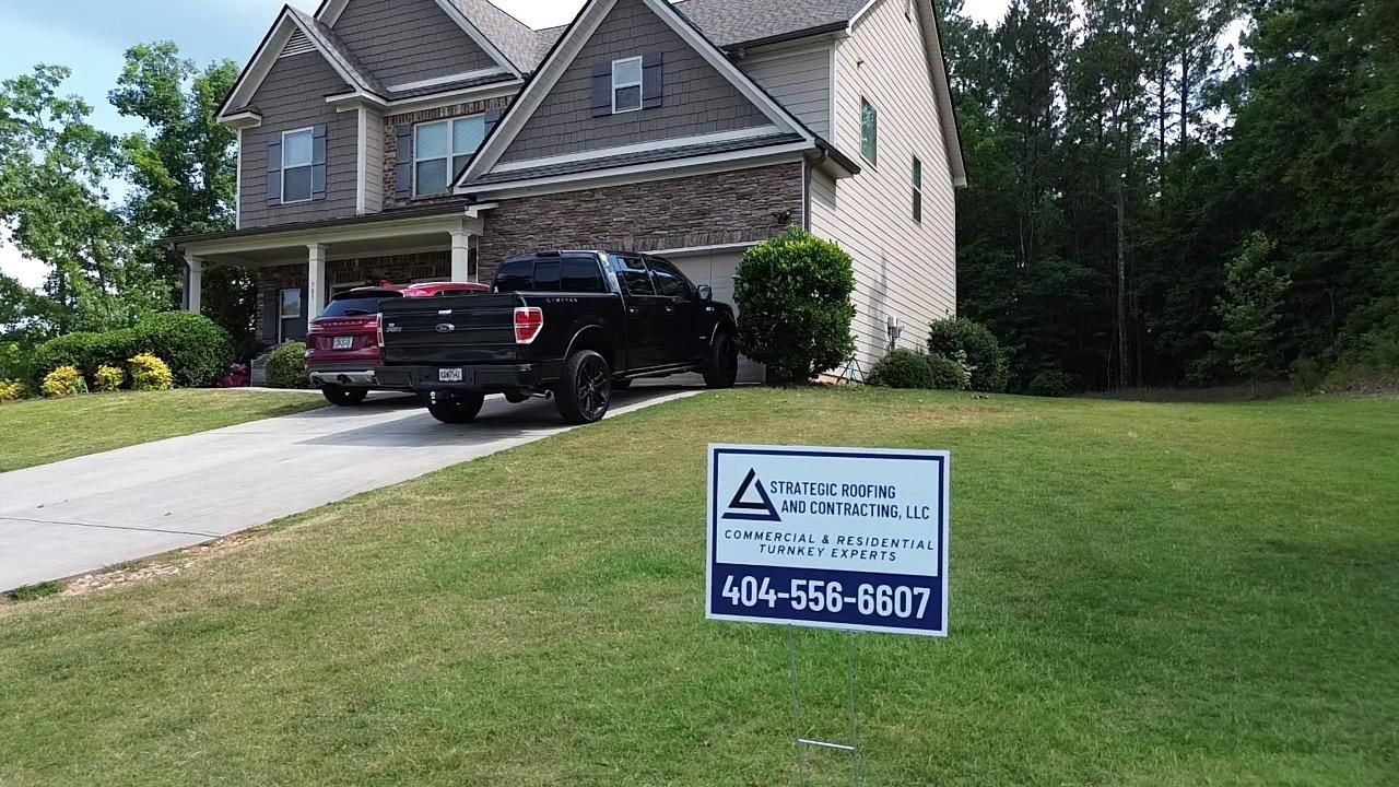A truck is parked in front of a house with a sign in front of it.