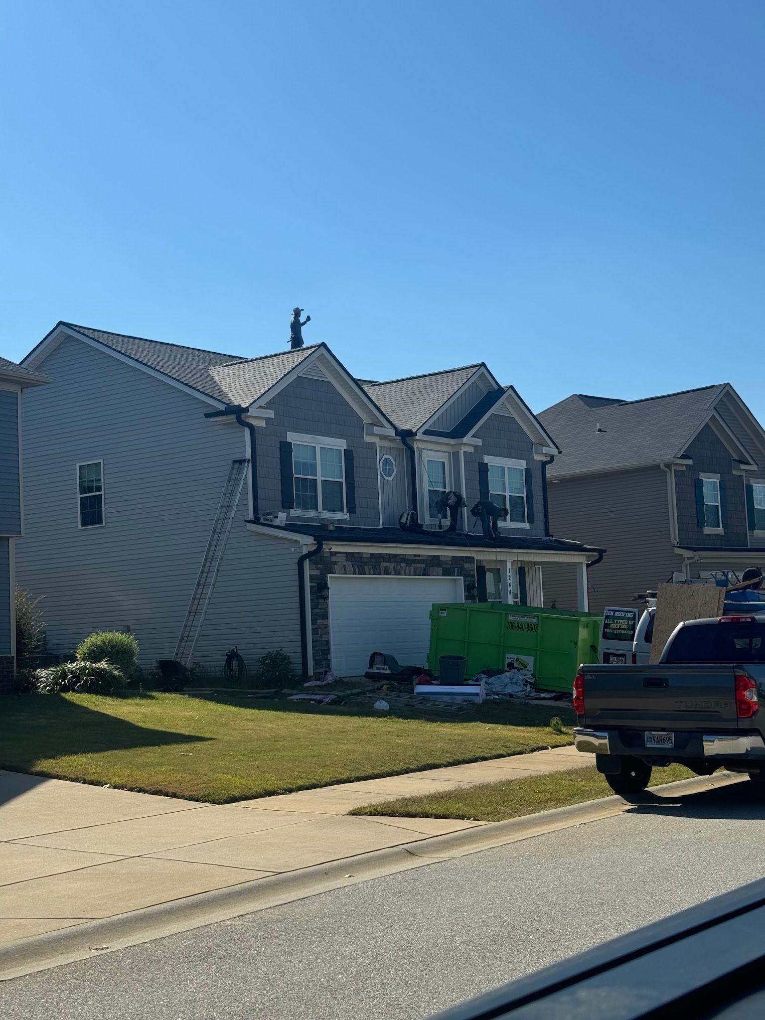A truck is parked in front of a house that is being painted.