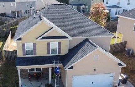An aerial view of a house with a new roof being installed.