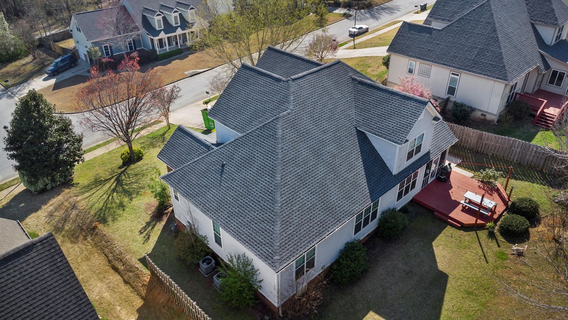 An aerial view of a house with a new roof in a residential area.
