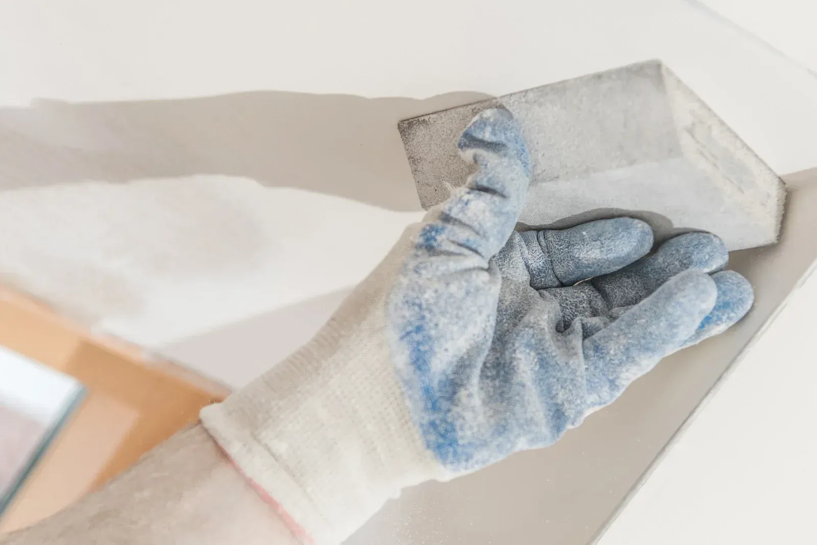 A person wearing a glove is holding a piece of concrete.
