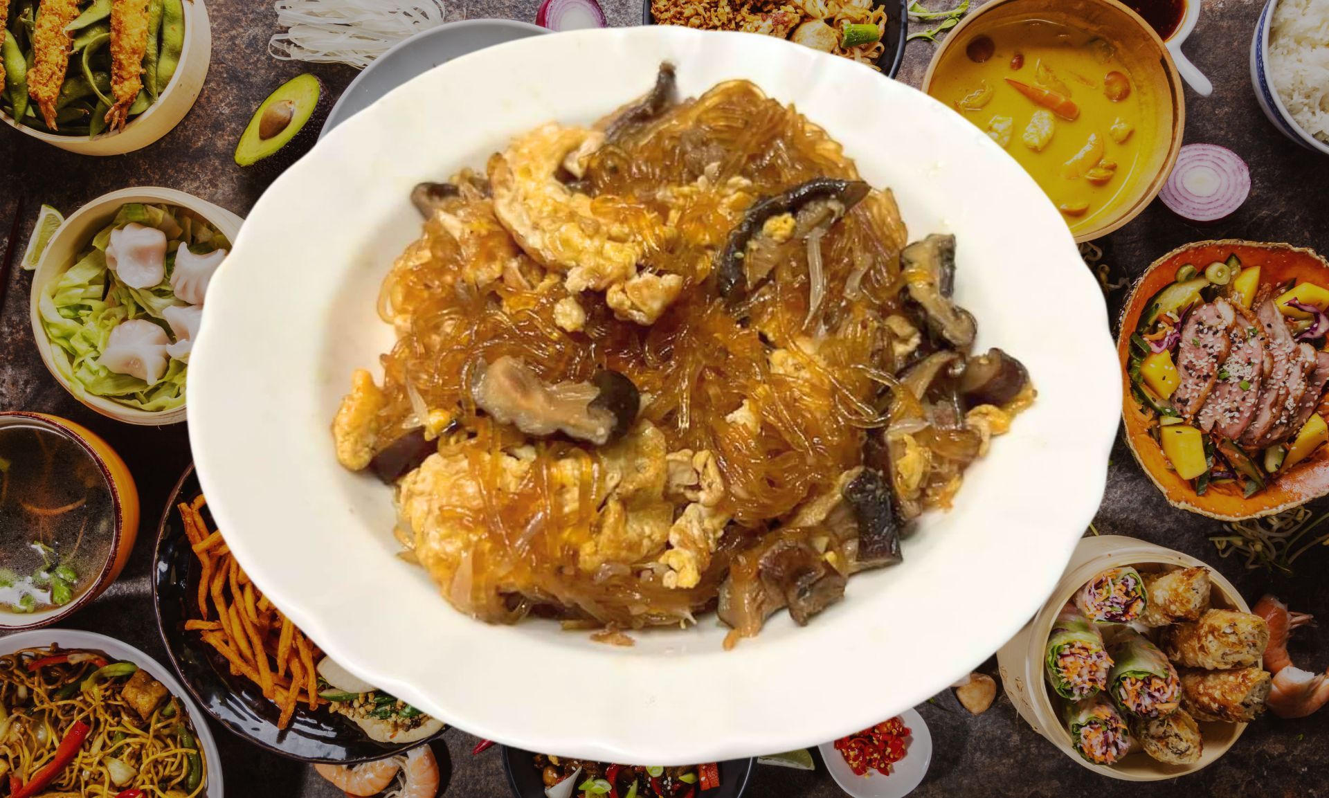 桌上放著一盤食物，周圍擺滿了食物碗。