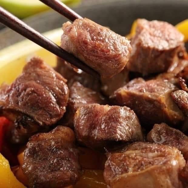 夾著一塊肉的筷子的特寫