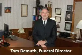 Man standing in an office, with caption “Tom Demuth, Funeral Director”