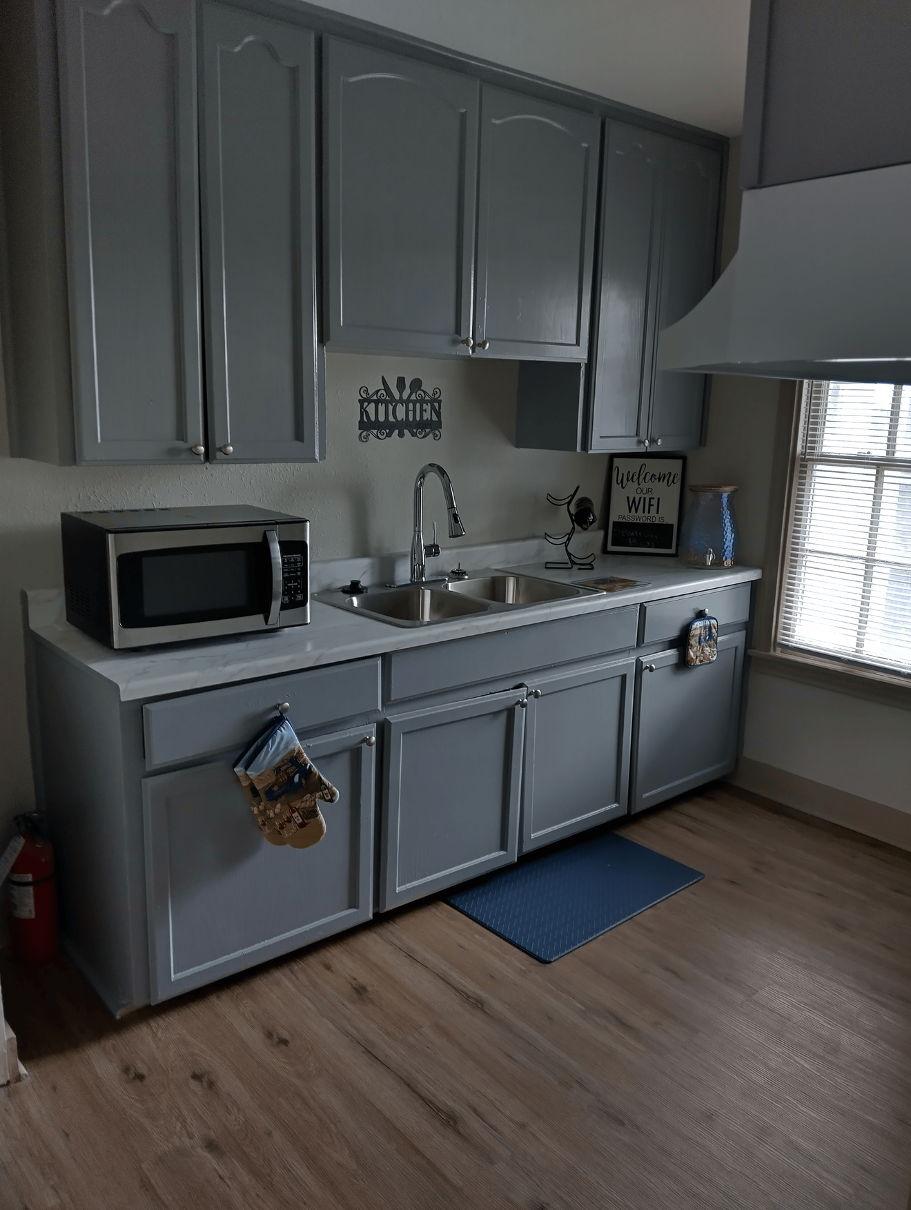 Ktichen with grey cabinets microwave and kitchen sink