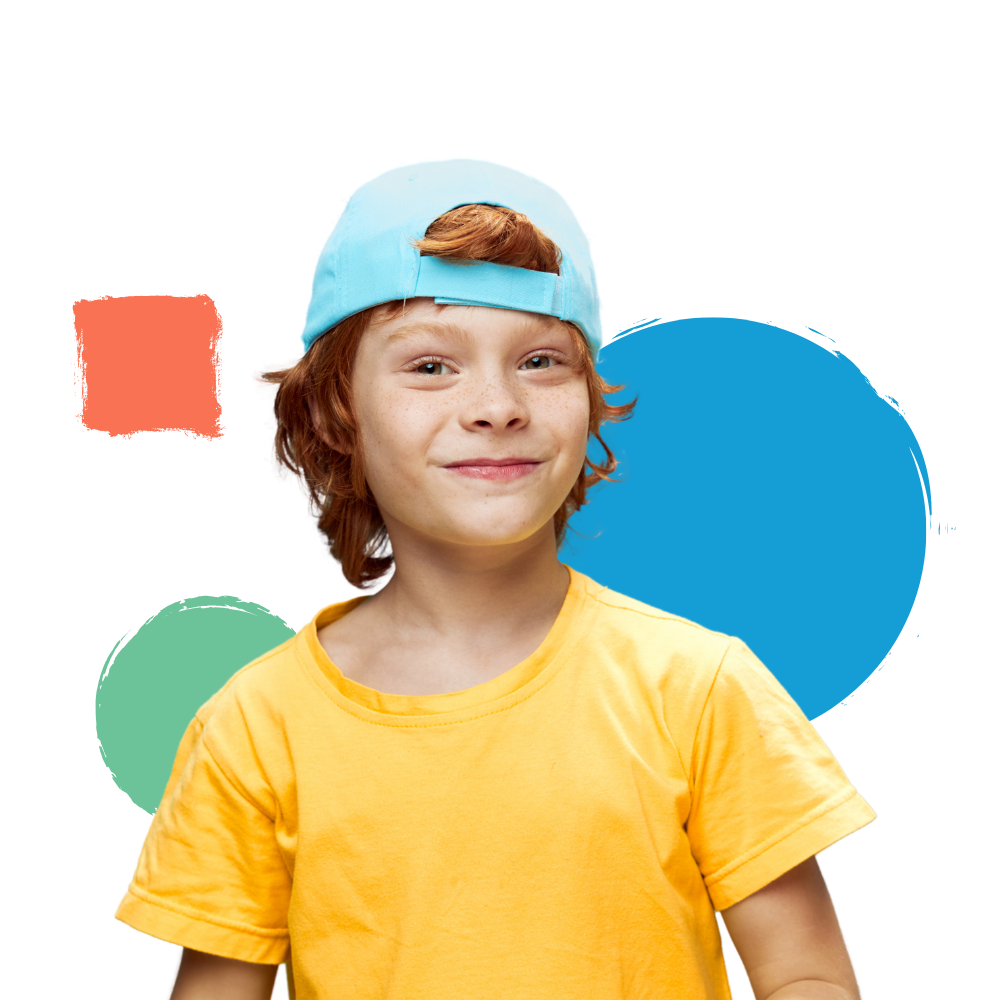 A young boy wearing a yellow shirt and a blue hat is smiling.