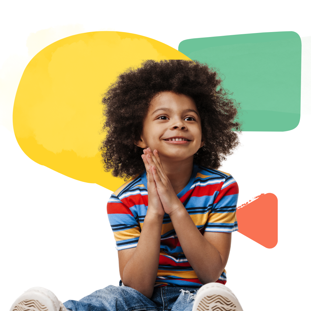 A young boy with curly hair is sitting in front of a yellow and green speech bubble.