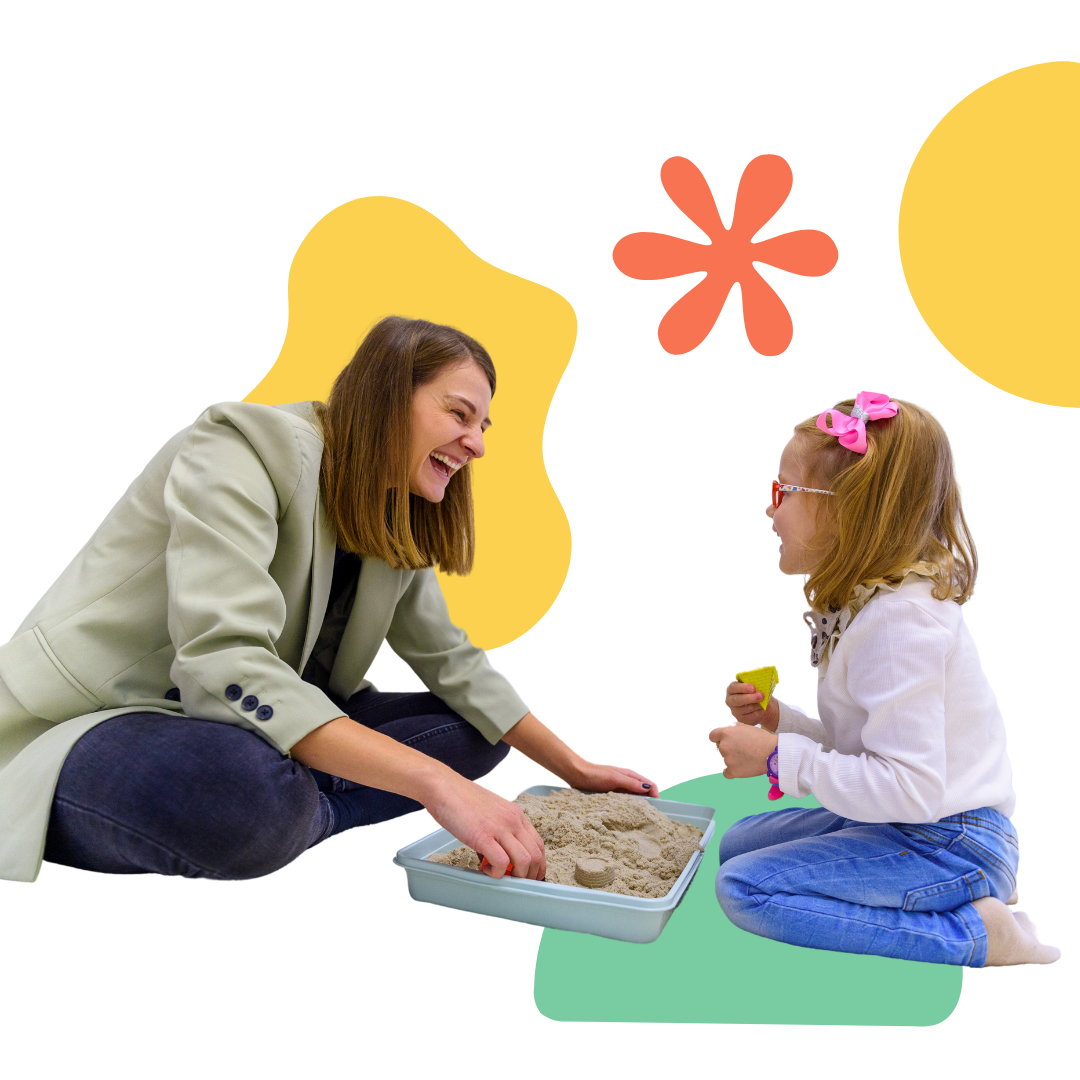 A woman and a little girl are playing with sand.