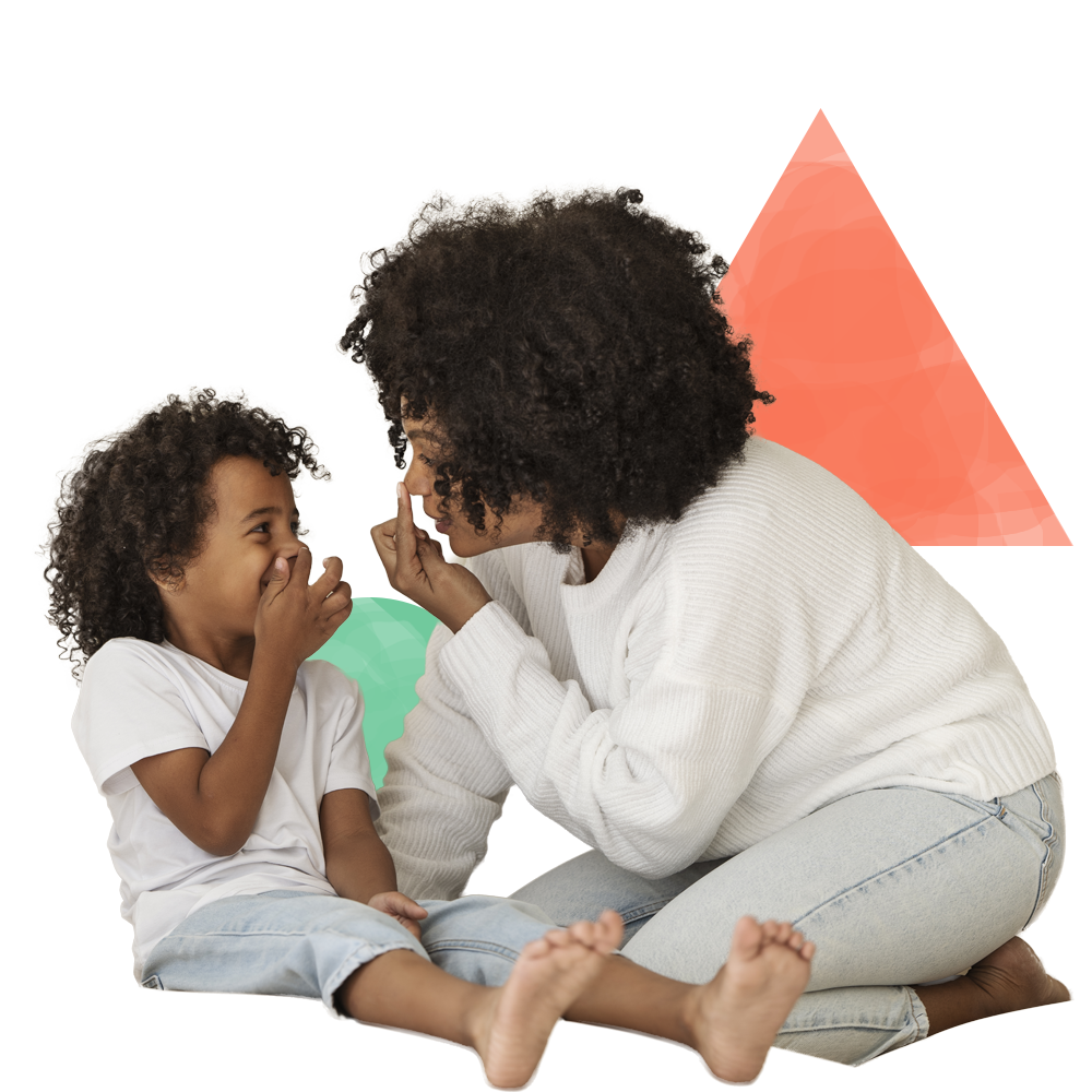 A woman and child are sitting on the floor playing with each other.