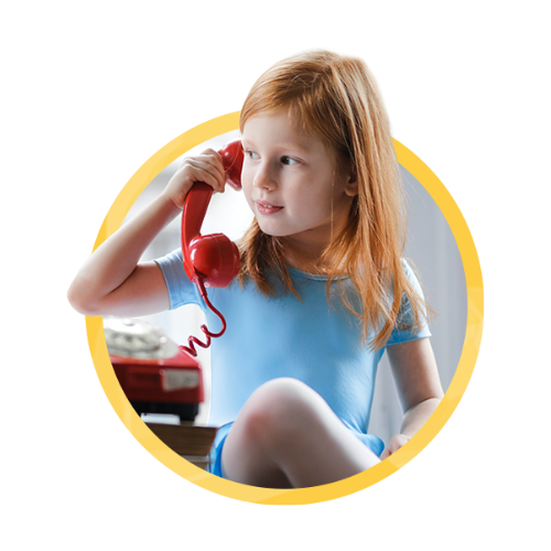 A little girl on a red telephone making conversation