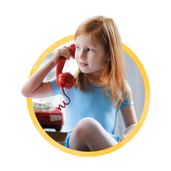 A little girl on a red telephone making conversation