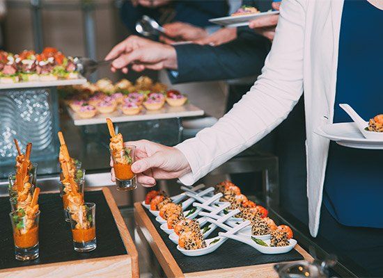 Woman Taking Snack from Buffet Table — Newtown, PA — Piccolo Trattoria Italian Catering