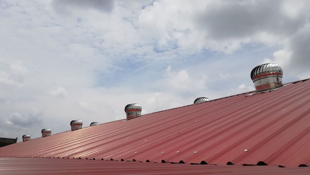 A Red Roof with A Blue Sky in The Background — Roof Masters NQ in Douglas, QLD