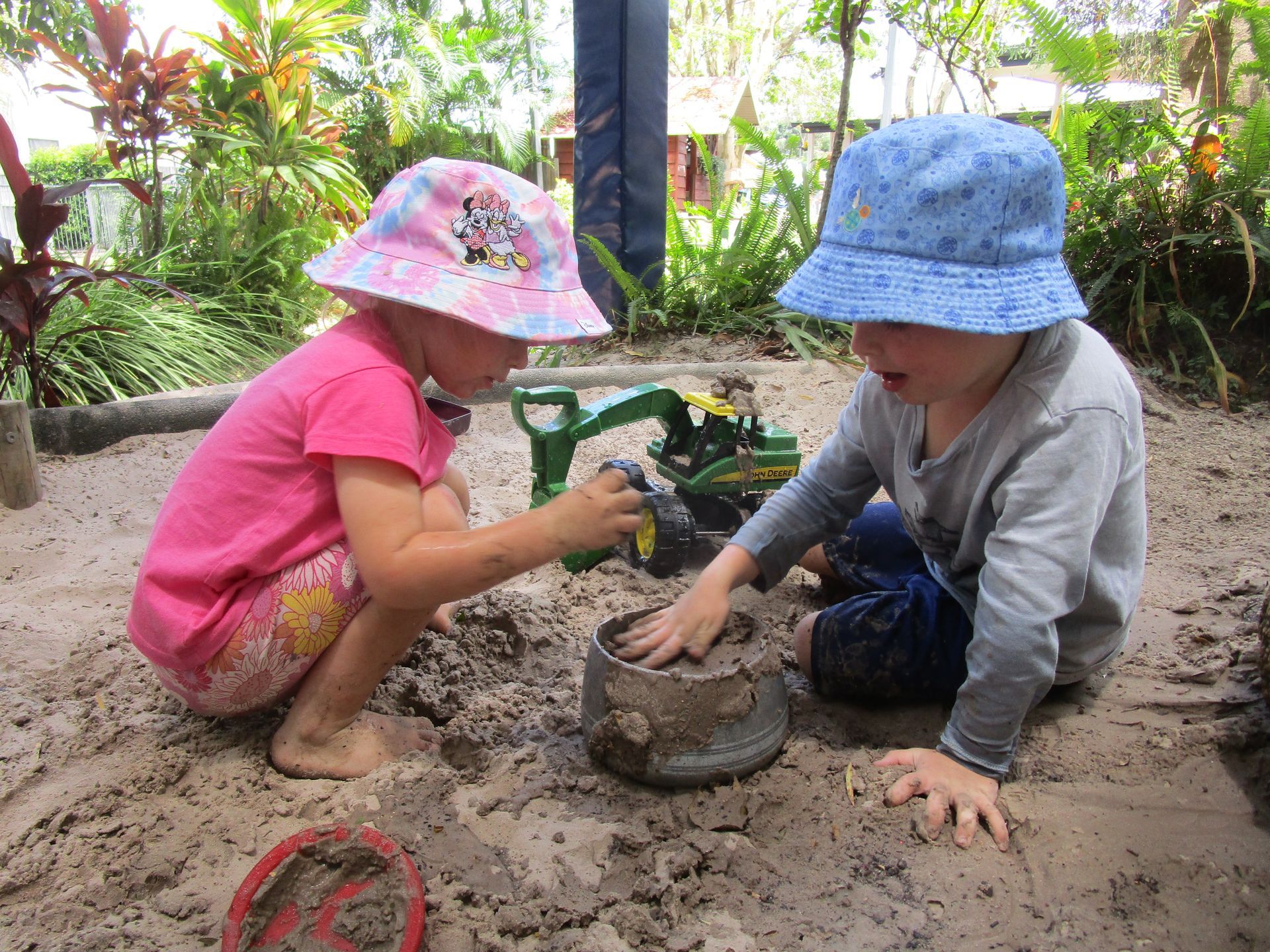 Two kids playing in the sand pit.