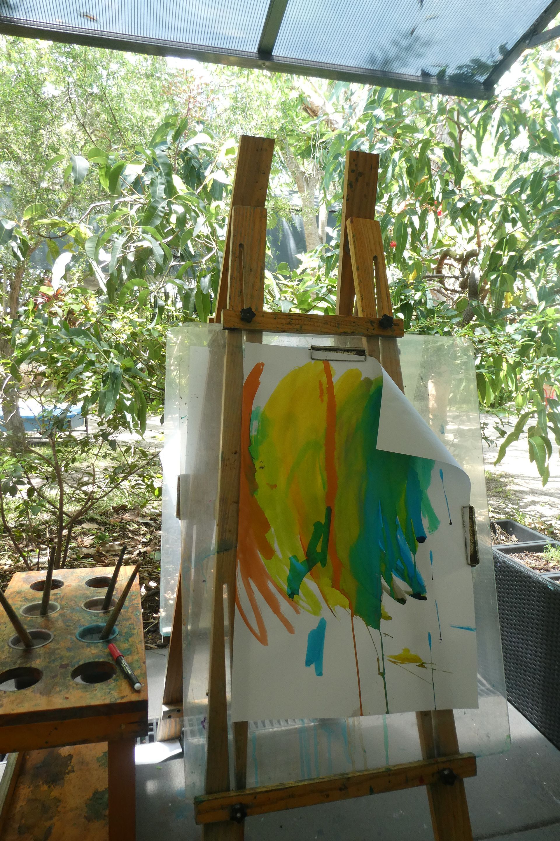 Wooden easel with colorful abstract painting outdoors.
