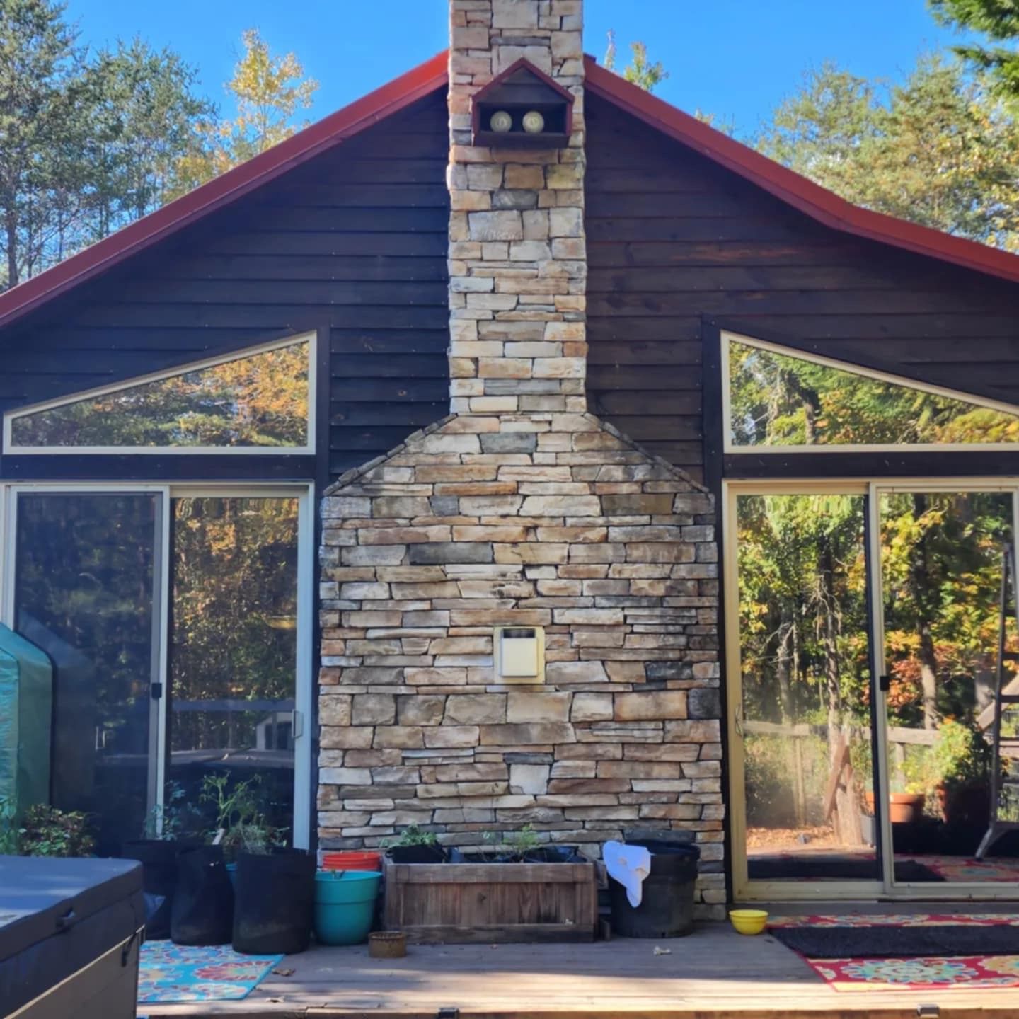 A house with a stone chimney and a sliding glass door