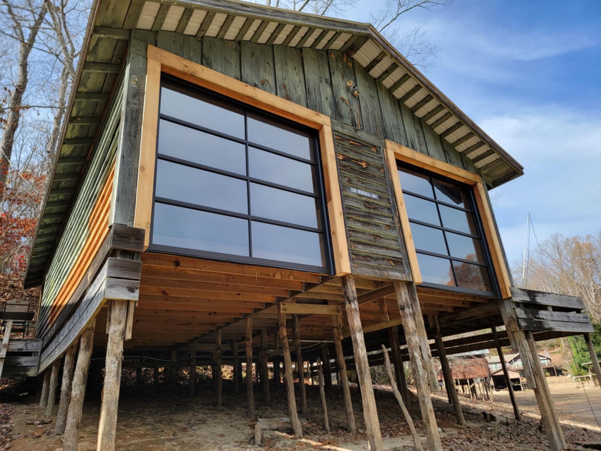 A small house is sitting on stilts in the middle of a forest.