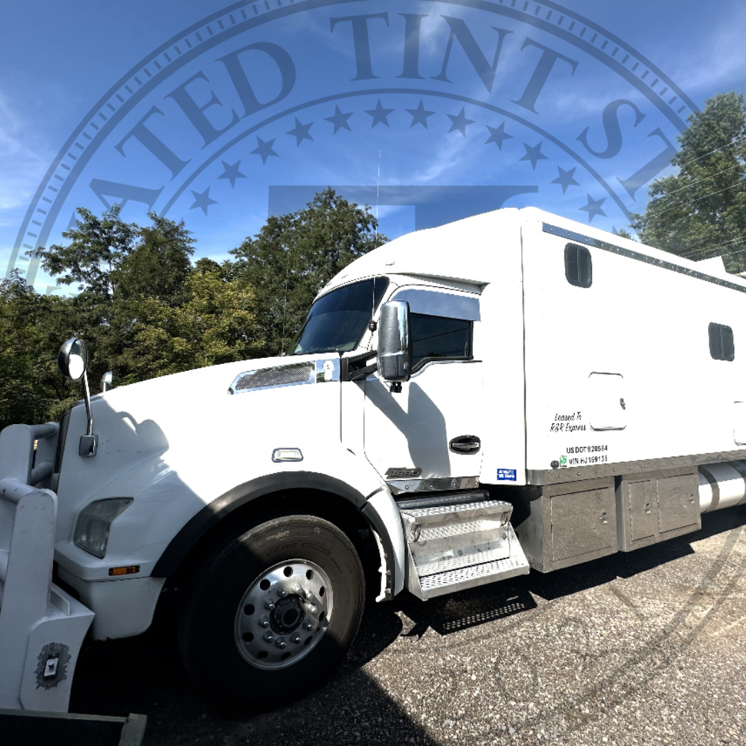 A white semi truck is parked on the side of the road