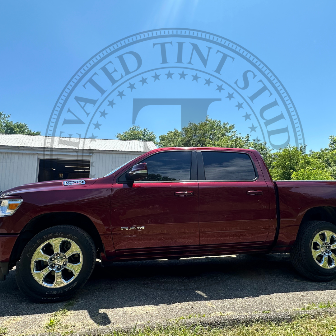 A red truck is parked on the side of the road in front of a building.