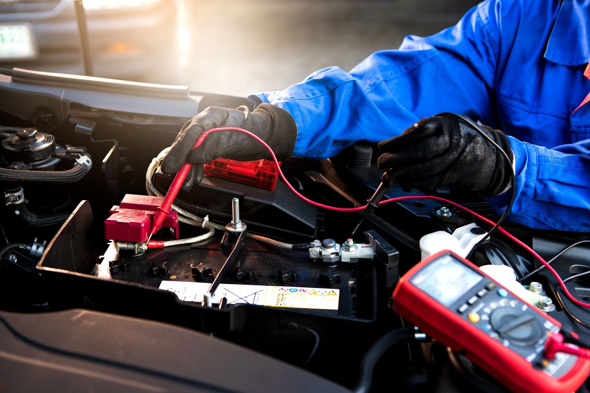 A man is working on a car battery | Baldy's