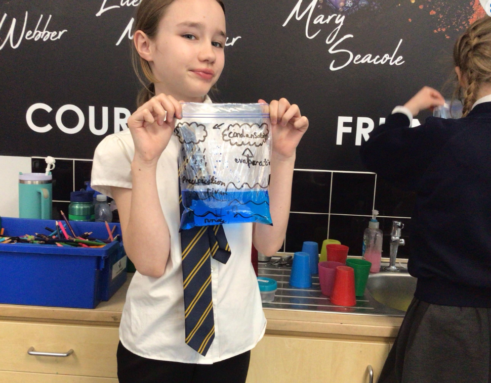 A girl in a tie holds up a bag