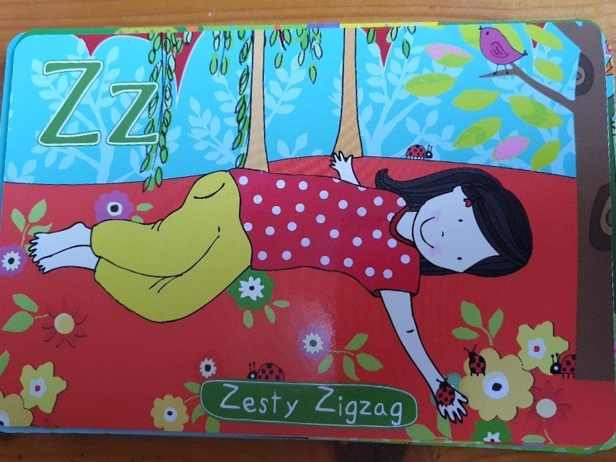 Girl in a red polka dot shirt lying on red flowers; with 