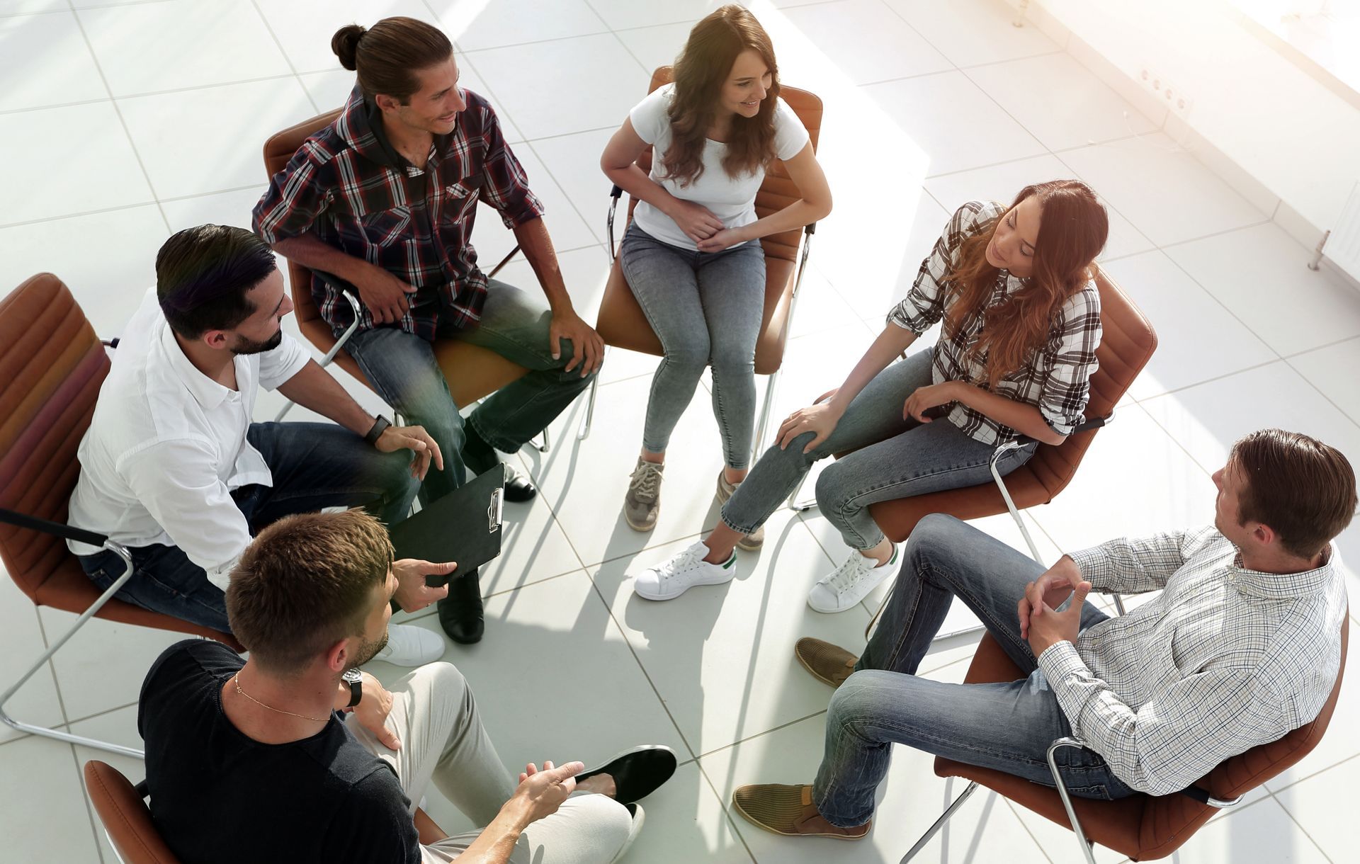 A group of people are sitting in chairs in a circle.