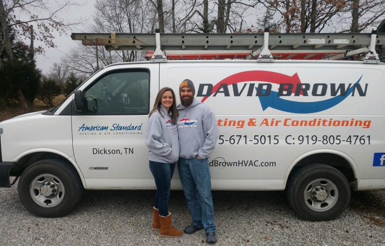 David Brown Heating & Cooling owners in front of work truck.