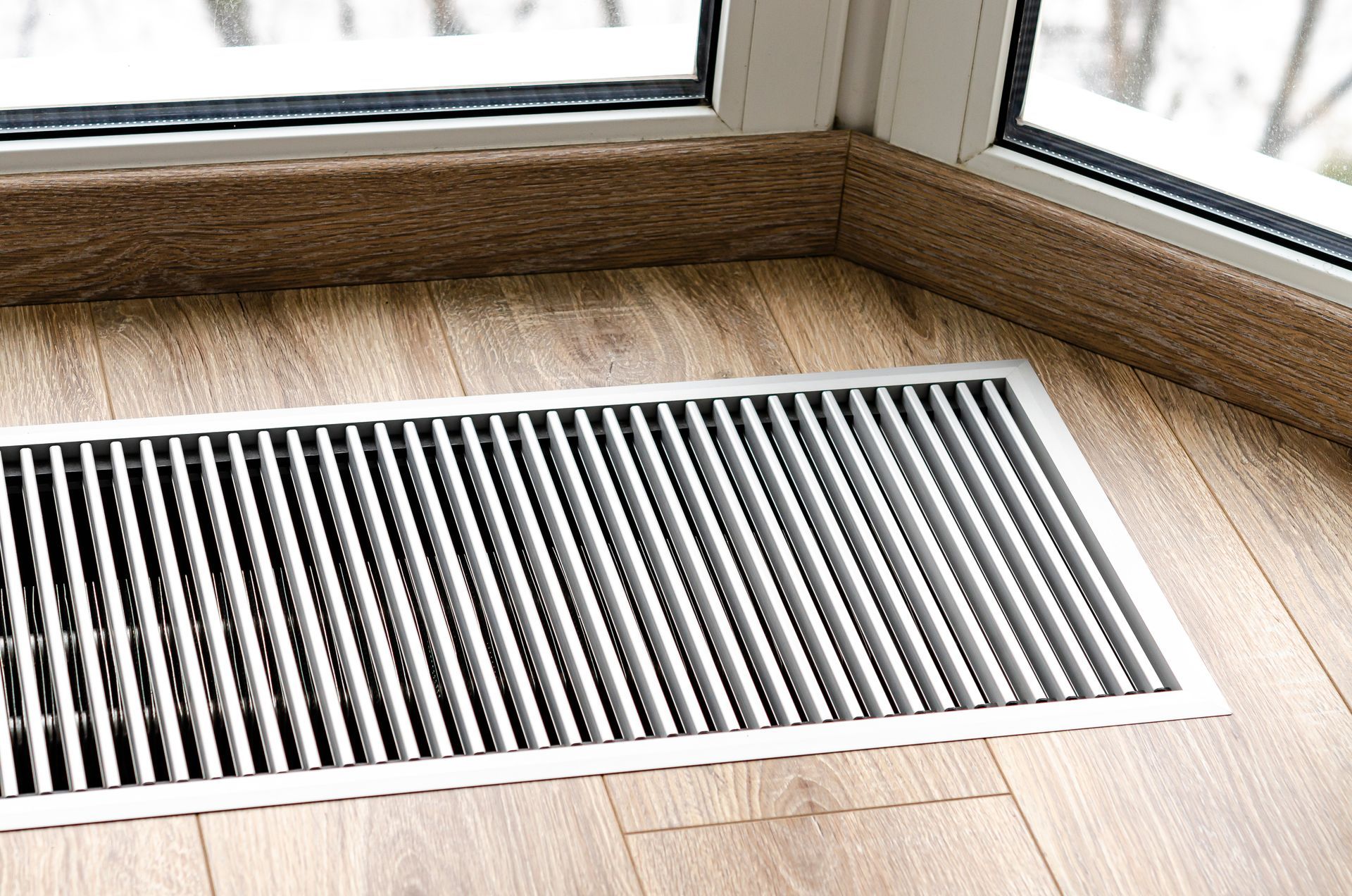 a protective heating grille mounted on the floor blowing cool air
