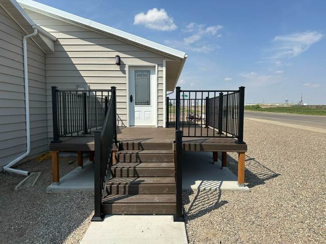 A house with a deck and stairs in front of it